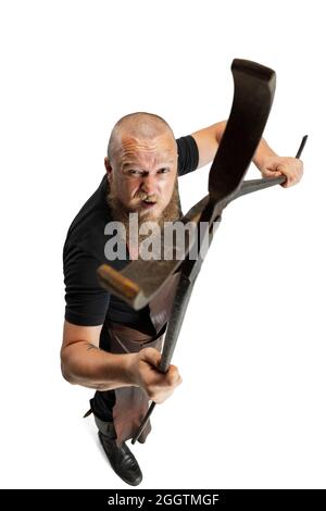 Vue en grand angle sur le chauve barbu, forgeron portant un tablier en cuir ou uniforme isolé sur fond blanc de studio. Concept de travail, rétro Banque D'Images