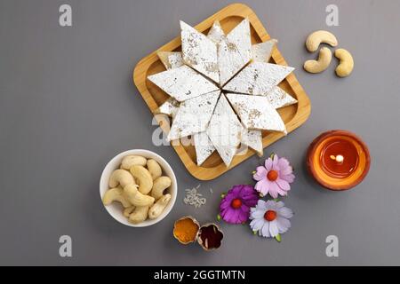 Kaju Katli est un traditionnel indien en forme de diamant doux ou Mithai fait à l'aide de la pâte de cajou, sucre, et mava ou Koya. Servi dans une assiette en bois. Banque D'Images