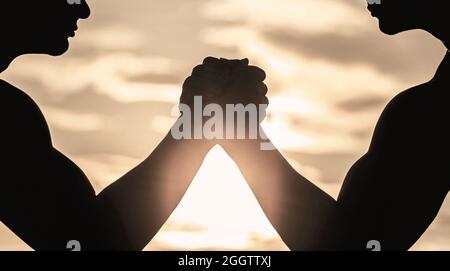 Silhouette de mains qui rivalisent en force. Rivalité, gros plan de lutte de bras mâle. Hommes mesurant les forces, les bras. Deux hommes lutte bras. Rivalité, vs Banque D'Images