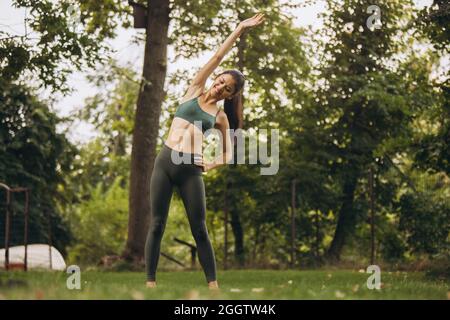 Potitrait pleine longueur de jeune belle femme pratiquant le yoga en plein air Banque D'Images