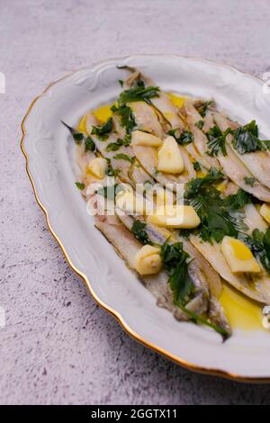 Anchois marinés dans du vinaigre et de l'huile d'olive avec du persil et de l'ail. Banque D'Images