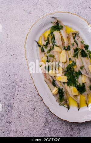 Anchois marinés dans du vinaigre et de l'huile d'olive avec du persil et de l'ail. Banque D'Images