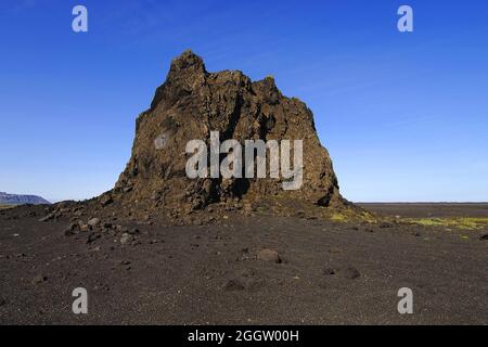 Grand crag de basalte ou pinacle sur une plaine de cinder à l'est de la ville de Vik, Islande Banque D'Images