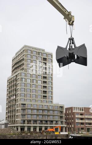 Nouveau bâtiment d'appartements sur les anciens quais de Gand en laissant les grues comme monuments du passé Banque D'Images