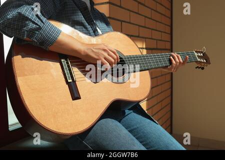 Femme en chemise jouant à la guitare classique Banque D'Images
