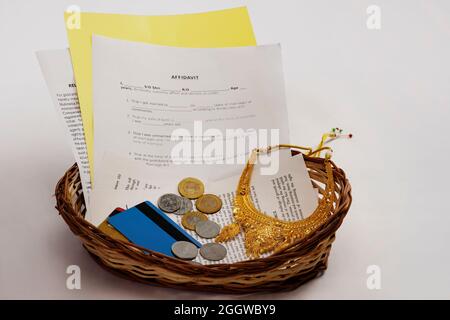 Un panier composé de mariage affadavit, pièces de monnaie, bijoux d'or et carte de crédit montrant des économies pour le mariage. Banque D'Images