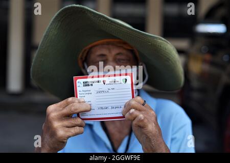 Makassar, Indonésie. 03ème septembre 2021. Un mendiant qui est également handicapé montre une carte vaccinale après avoir reçu une vaccination Covid-19 au quartier général de la brigade mobile de la police de Sulawesi Sud. La Brigade mobile de la police de Sulawesi du Sud a effectué une vaccination de masse pour les mendiants et les personnes handicapées afin d'atteindre l'objectif de vaccination pour les populations de Sulawesi du Sud jusqu'à 80 pour cent. (Photo de Herwin Bahar/Pacific Press) crédit: Pacific Press Media production Corp./Alay Live News Banque D'Images