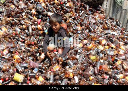 Dhaka, Bangladesh, 03/09/2021, Un enfant sépare les bouteilles de polyéthylène téréphtalate (PET) dans une usine de recyclage située à la périphérie de Dhaka. Le recyclage des bouteilles en plastique est devenu une activité en pleine croissance au cours des deux dernières années et contribue à protéger l'environnement. Selon la Bangladesh PET Flakes Manufacturers and Exportateurs Association (BPFMEA), le Bangladesh exporte en moyenne près de 30,000 tonnes de flocons de bouteilles en PET, principalement vers la Chine, la Corée du Sud et Taïwan, pour une valeur de 14 millions de dollars par an. Le 3 septembre 2021. (Photo de Habibur Rahman / Eyepix Group) Banque D'Images