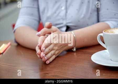 Les mains des femmes dans l'espoir, dans la prière. Mouvement de la main. Paumes ensemble sur la table. Photo de haute qualité Banque D'Images