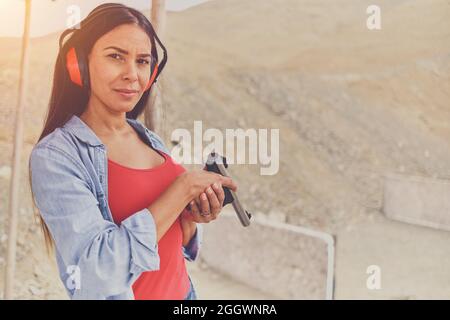 Femme libérant le stress, instructeur aidant la femme avec le pistolet Banque D'Images