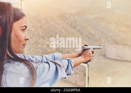 Femme libérant le stress, instructeur aidant la femme avec le pistolet Banque D'Images
