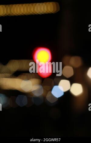 flou artistique magnifique effet bokeh scintillant de voitures et de feux de circulation la nuit. Brouillé circulation de la ville bourrage dans la rue de la ville. Défoqué lumière colorée Banque D'Images
