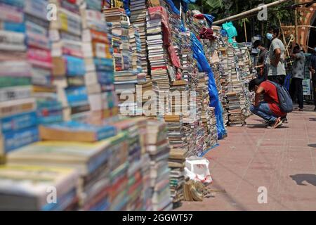 Dhaka, Bangladesh. 3 septembre 2021. Un homme regarde des livres empilés qui ont été mis aux enchères à des prix très bas sur le marché extérieur en raison de la fermeture des librairies en raison du manque de ventes en raison de la situation Covid-19. Les anciennes librairies de la capitale Newmarket ont subi des pertes dues à la fermeture des établissements d'enseignement depuis longtemps en raison de la prévalence de Covid-19. Le 3 septembre 2021 à Dhaka, au Bangladesh. Credit: EYEPIX Group/Alamy Live News Credit: EYEPIX Group/Alamy Live News Banque D'Images