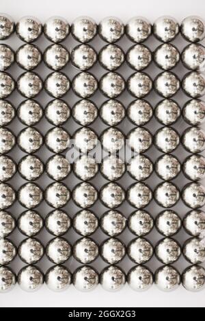 Boules métalliques gros plan. Billes de néodyme (aimants). Carrelage à roulement à billes magnétiques en grille hexagonale parfaite Banque D'Images