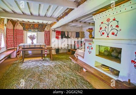 PEREIASLAV, UKRAINE - 22 MAI 2021: Intérieur de la maison traditionnelle ukrainienne hata avec poêle en adobe classique et beaucoup de serviettes décoratives rushnyk, P Banque D'Images