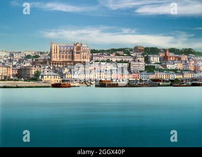 Vue du début du XXe siècle sur l'église de la cathédrale Saint-Colman, alias la cathédrale de Cobh, qui surplombe les maisons en terrasse de Cobh, comté de Cork, en Irlande. La construction a commencé en 1868 et la photographie illustre le bâtiment avant l'installation du clocher existant. Conçu par les architectes Edward Welby Pugin et George Ashlin, il n'a été achevé que plus d'un demi-siècle plus tard en raison de l'augmentation des coûts et des révisions des plans originaux Banque D'Images