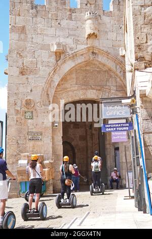 JÉRUSALEM, ISRAËL - 14 août 2021 : porte de Jaffa à Jérusalem, Israël avec des personnes qui voyagent sur des véhicules Segway avec des casques jaunes Banque D'Images