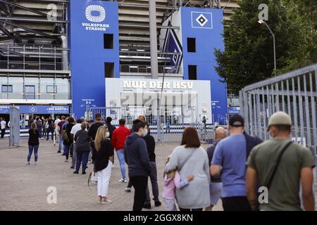 Hambourg, Allemagne. 03ème septembre 2021. Les personnes qui veulent être vaccinées font la queue devant le Volkspark Stadium de Hambourg. Le Hamburger SV invite à une action de vaccination dans le stade. Entre 17:00 et 23:00, les fans et les visiteurs peuvent se faire vacciner sans rendez-vous. Les participants seront invités à une visite gratuite du stade et recevront également une réduction dans la boutique des fans le premier jour. Crédit : Ulrich Perrey/dpa/Alay Live News Banque D'Images