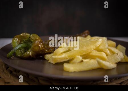 Frites avec poivrons frits, une nourriture très populaire dans le sud de l'Espagne. Les pommes de terre ne doivent pas être congelées et toutes faites maison. Tout cela avec de l'huile d'olive. Banque D'Images