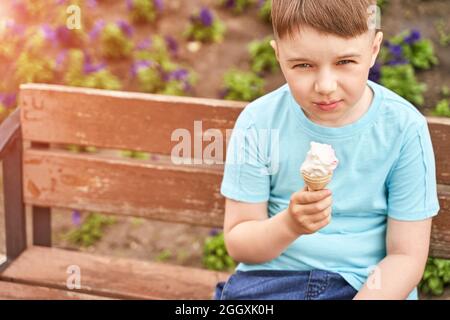 Un enfant sympa qui mange de la glace au parc. Concept de vacances. Style de vie de Staycation Banque D'Images