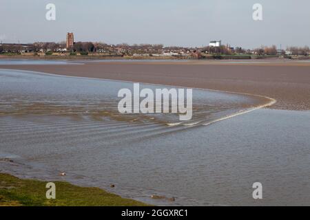 Le Mersey Tidal Bore approchant le parc communautaire de Wigg Island à Runcorn avec Widnes au loin Banque D'Images