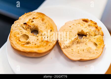 Pain de bagel tranches de pain grillées sur une assiette blanche comme nourriture de petit déjeuner sans garniture Banque D'Images