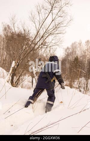 un chasseur de ski se met en route ou s'emmêle dans la neige profonde et tombe dans la neige Banque D'Images