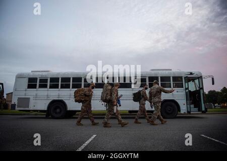 Les membres du 822e Escadron de défense de la base embarquent à bord d'un autobus qui se dirige de l'édifice de leur escadron vers le centre de contrôle du déploiement de la base aérienne Moody, en Géorgie, le 28 août 2021. Au cours de deux jours, plus de 160 aviateurs sont partis pour la base aérienne de Holloman, au Nouveau-Mexique, en appui à la Force opérationnelle – Holloman. Le ministère de la Défense, par l'intermédiaire du Commandement du Nord des États-Unis, et en appui au ministère de la sécurité intérieure, fournit des services de transport, de logement temporaire, de dépistage médical et de soutien général à au moins 50,000 personnes évacuées afghanes dans des installations appropriées, en structure permanente ou temporaire Banque D'Images