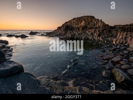 Coucher de soleil sur les colonnes de basalte de la chaussée des géants dans le comté d'Antrim, en Irlande du Nord Banque D'Images
