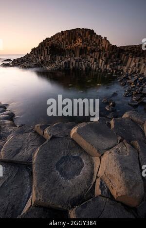Coucher de soleil sur les colonnes de basalte de la chaussée des géants dans le comté d'Antrim, en Irlande du Nord Banque D'Images