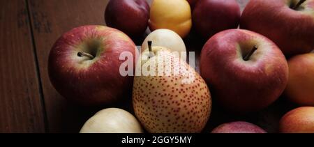 Fruits juteux sur une vieille table en bois. Pommes, poires, prunes, abricots, gros plan. Banque D'Images