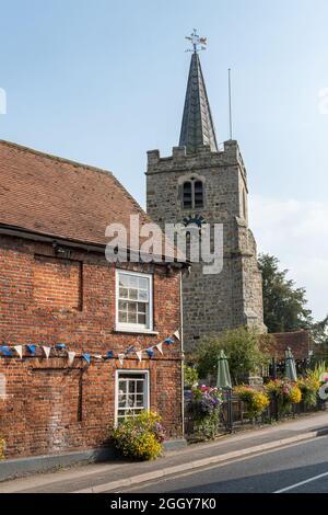 La rue High Street dans le village de Chobham, Surrey, Angleterre, Royaume-Uni, avec l'église Saint-Laurent Banque D'Images