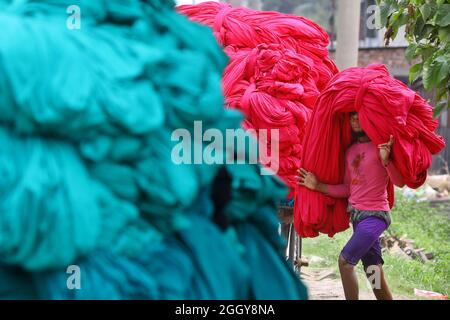 Narayanganj, Bangladesh. 03ème septembre 2021. Un ouvrier bangladais recueille des tissus peints après les avoir séchés sous le soleil dans une usine de teinture à Narayanganj, près de la capitale Dhaka. La plupart des travailleurs souffrent de maladies de la peau par contact constant avec les produits chimiques utilisés pour teindre le tissu, en raison de l'absence de mesures de précaution appropriées. Le 03 septembre 2021 à Narayanganj City, Bangladesh. (Photo de Harun-or-Rashid / Groupe Eyepix) Credit: EYEPIX Group/Alamy Live News Banque D'Images