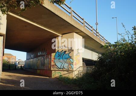 Vue à angle bas d'un pont souterrain avec murs recouverts de graffitis Banque D'Images