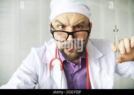 Un barbu croisé regarde dans le cadre. Maladie oculaire. Le concept de spécialiste médical fou. Médecin voisin. Banque D'Images