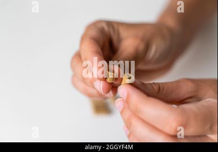 Gros plan avec une capsule d'herbe sur fond blanc. Concept de microdosage. Thérapie de psychédéliques. Dépression, traitement de l'anxiété Banque D'Images