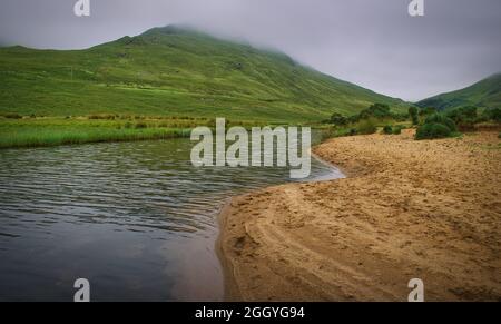 Magnifique paysage de plage de sable et de collines verdoyantes en arrière-plan au Loch na Foogeey dans le parc national du connemara dans le comté de Galway, en Irlande Banque D'Images