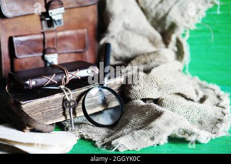 Vieux sac en cuir avec une loupe sur une table en bois brun voyageur espace de copie de fond. Banque D'Images