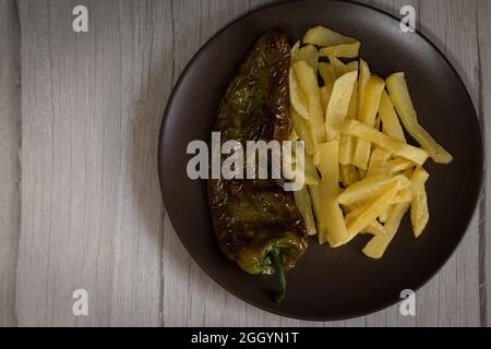 Frites avec poivrons frits, une nourriture très populaire dans le sud de l'Espagne. Les pommes de terre ne doivent pas être congelées et toutes faites maison. Tout cela avec de l'huile d'olive. Banque D'Images