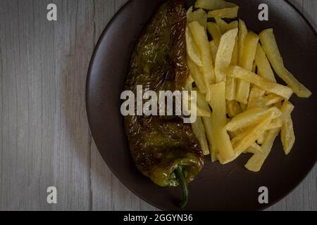 Frites avec poivrons frits, une nourriture très populaire dans le sud de l'Espagne. Les pommes de terre ne doivent pas être congelées et toutes faites maison. Tout cela avec de l'huile d'olive. Banque D'Images