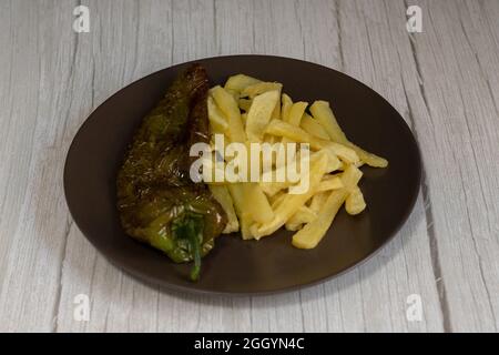 Frites avec poivrons frits, une nourriture très populaire dans le sud de l'Espagne. Les pommes de terre ne doivent pas être congelées et toutes faites maison. Tout cela avec de l'huile d'olive. Banque D'Images