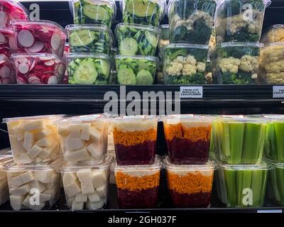 Légumes fraîchement coupés dans des contenants en plastique disposés sur les tablettes de l'épicerie Banque D'Images