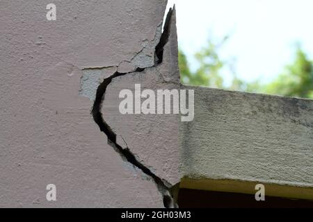 Fond de mur de ciment rose fissuré et peinture écaillée. Banque D'Images