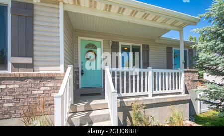 Pano extérieur d'une maison avec des briques, porche surélevé et fenêtres à double vitrage Banque D'Images