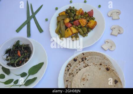 Nourriture indienne: Plat de matar paneer mélange veg, saag (verts) et roti (chapati) isolé sur fond blanc Banque D'Images