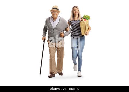Portrait complet d'une jeune femme portant un sac d'épicerie et aidant un homme âgé isolé sur fond blanc Banque D'Images