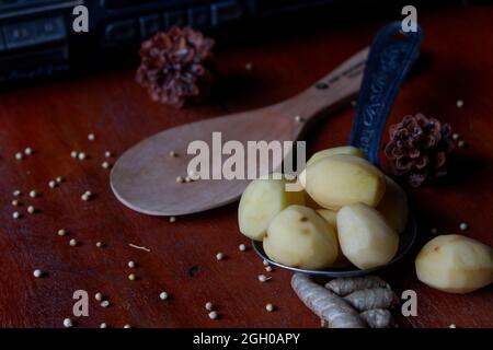 Gros plan d'épices de cuisine sous forme de pommes de terre, curcuma, poivre blanc sur une table Banque D'Images