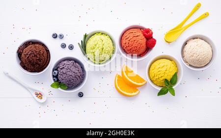 Divers de crème glacée saveur de bleuets ,balle ,lime ,pistache ,amandes chocolat et vanille, orange sur fond de bois blanc . L'été et Swee Banque D'Images