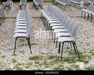 groupe de chaises en plastique gris vides disposées en rangées en attendant les gens après la pandémie de covid 19 du coronavirus Banque D'Images