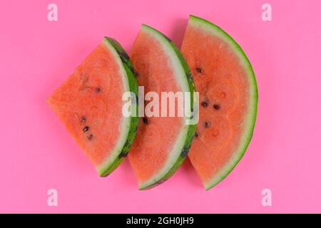 Pastèque en tranches sur fond rose. Morceaux de pastèque isolés sur fond rose. Pose à plat. Banque D'Images